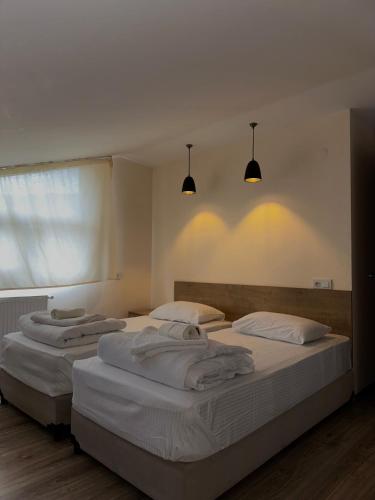 Tres camas en una habitación con luces en la pared. en Smiths house, en Surami