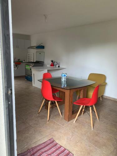 a kitchen with a table and four red chairs at Casa Vazquez San francisco in Pachuca de Soto