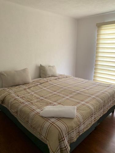 a bed with a blanket and a window in a room at Casa Vazquez San francisco in Pachuca de Soto