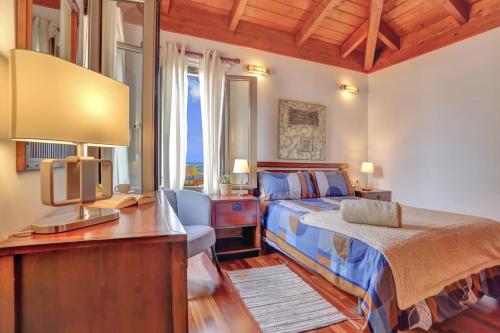 una camera da letto con un letto e una scrivania con una televisione di Villa Charly a Puerto de la Madera