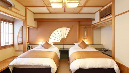 a room with two beds and a window at Ryokan Shinsen in Takachiho