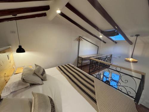 a bedroom with a white bed and a balcony at CASA CRISTOBAL Siete Cuartones in Cusco