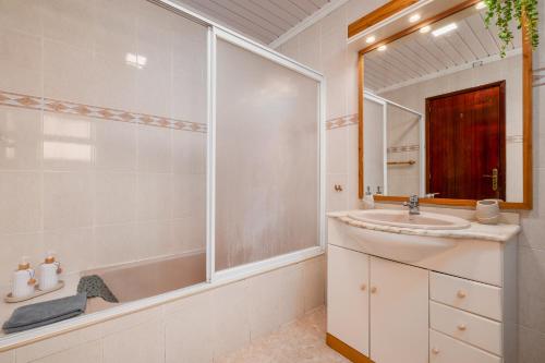 Un baño con lavabo, bañera y espejo. en Casa Mar, en Ponta Delgada