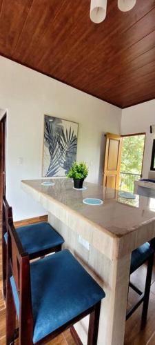 a kitchen with a counter with blue chairs and a counter top at Villa Marina, Nosara in Nosara