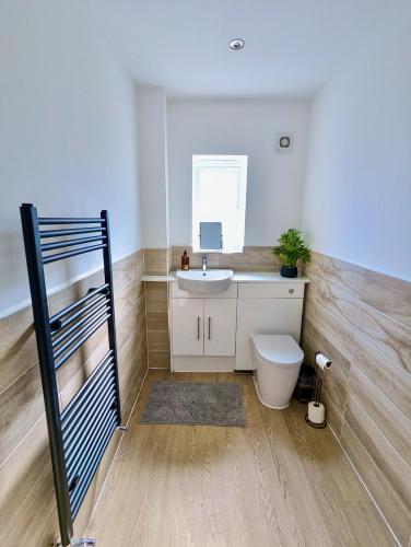 ストックポートにあるSpacious and Modern Entire Home with Gardenのバスルーム(シンク、トイレ付)、二段ベッド1組が備わります。