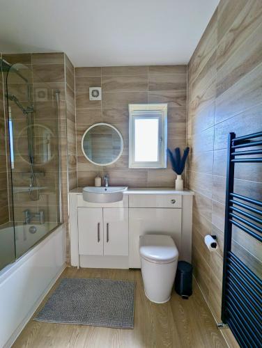 ストックポートにあるSpacious and Modern Entire Home with Gardenのトイレ、洗面台、シャワー付きのバスルーム