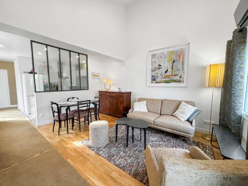 a living room with a couch and a table at La Parenthèse proche de Paris, Parking securisé, Terrasse privée, 1 chambre in Brétigny-sur-Orge