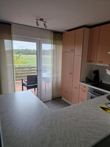 a kitchen with a table and a view of a patio at Sofija in Neustadt am Rübenberge