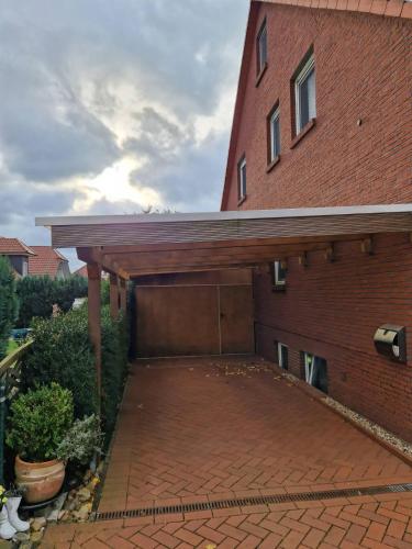 a brick building with a garage with a brick driveway at Sofija in Neustadt am Rübenberge