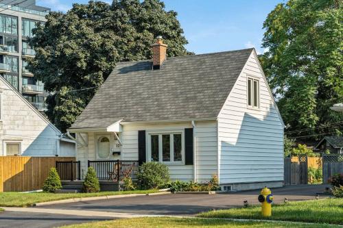 a white house with a chimney on top of it at Heritage 3BR Etobicoke Gem, Sherway Gardens, BBQ in Toronto