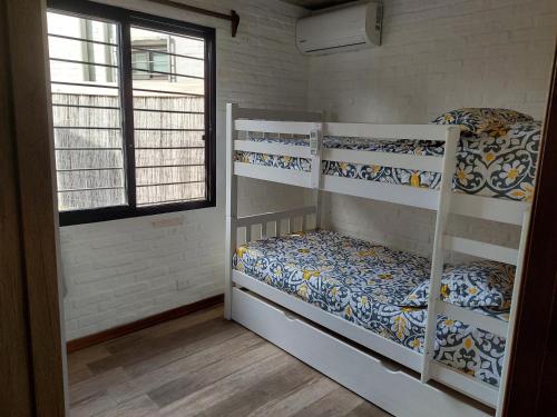 two bunk beds in a room with a window at Las Olas in Piriápolis