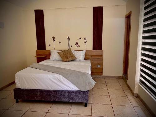 a bedroom with a bed with white sheets and pillows at Magiko Suites in Roldanillo