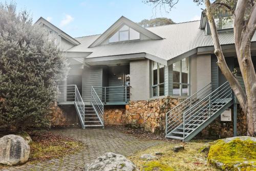 a house with a stone facade and a stone staircase at Wintergreen 11 in Thredbo