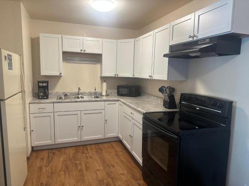 cocina con armarios blancos y lavavajillas negro en Cozy Remodeled Apartment near Green Bay & Appleton, en Kaukauna