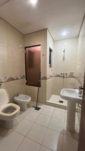 a bathroom with a toilet and a sink at Habitacion privada en casa familiar in San Bernardino