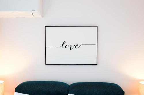 a living room with a picture of love on the wall at Bright Modern Holiday Home 7 Beds at Doncaster in Doncaster