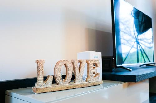 a wooden sign that says love sitting on a desk at Bright Modern Holiday Home 7 Beds at Doncaster in Doncaster