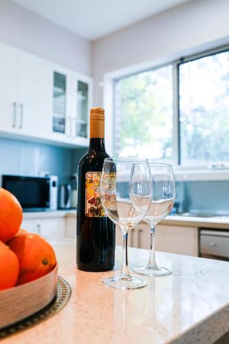 a bottle of wine and two wine glasses on a counter at Bright Modern Holiday Home 7 Beds at Doncaster in Doncaster