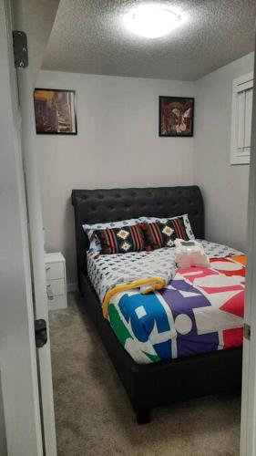 a bedroom with a bed with a colorful comforter at Carsonway Basement Suite in Edmonton