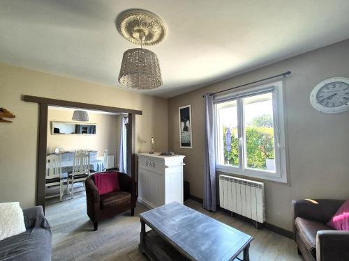 un salon avec un canapé, une table et une fenêtre dans l'établissement Holiday Home in Trelevern near Pink Granite Coast, à Trélévern