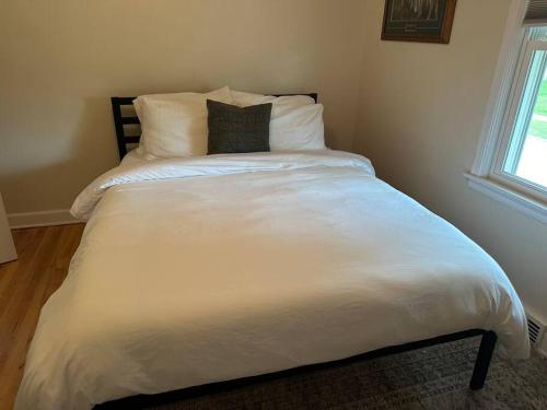 a large white bed with two pillows on it at Wilson Street Home in Little Chute