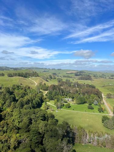 an overhead view of a field with trees and a road at The Rabbiter's Cottage in Kahuranaki