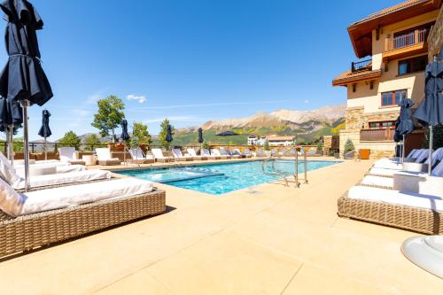 a pool at a hotel with lounge chairs at Forbes 5 Star Luxury Hotel - 1 Br Ski-in Ski-out Residence in Mountain Village Colorado in Telluride