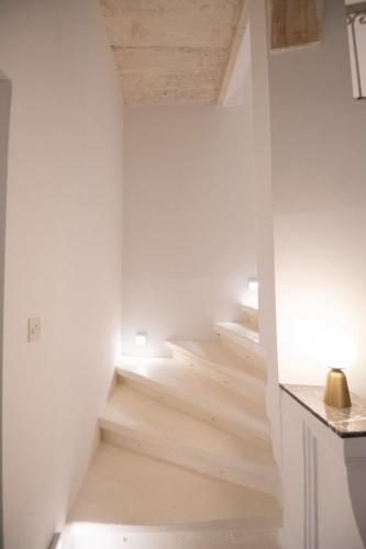 a staircase in a room with white walls and wooden floors at Authentic Maltese Boutique Holiday Home with Rooftop Pool - Moon Townhouse in Cospicua