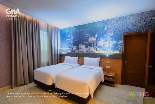 a hotel room with two beds and a painting on the wall at GIIA Maluku Hotel Thamrin Jakarta in Jakarta