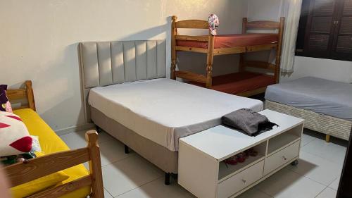 una camera da letto con due letti e un letto a castello e una scala di Linda casa Morada da Praia com piscina privativa e muito espaço pra você e seu pet a Bertioga