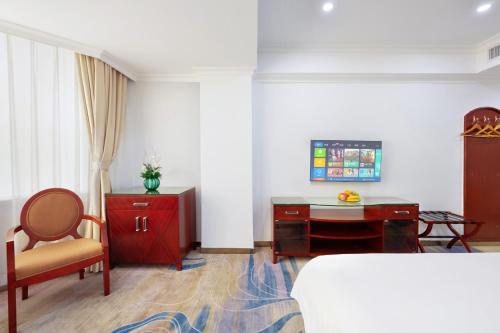 a bedroom with a bed and a desk and a chair at Guang Yun Hotel Guangzhou in Guangzhou