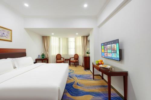 a hotel room with a large bed and a table at Guang Yun Hotel Guangzhou in Guangzhou
