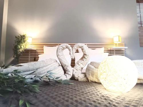 2 cygnes assis au-dessus d'un lit dans l'établissement Stylish 53m2 Suite in Paris - Terrace, Balcony, Free Parking & 5mn from Metro, à Ivry-sur-Seine