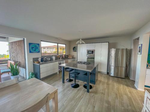 a large kitchen with a table in the middle of it at Fare Miri Ata Premium - 107m2 Panoramic view in Punaauia