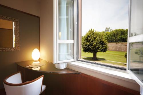 a room with a window with a desk and a lamp at Albergo Celide in Lucca