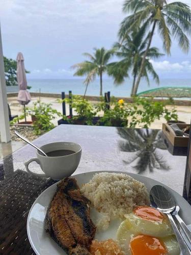 圣胡安South Cape Beach Resort的一张桌子上摆着一盘米饭和肉，窗外就是海滩。