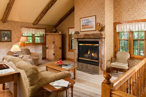 a living room with a fireplace and a couch at Chanticleer Cabins in Sturgeon Bay