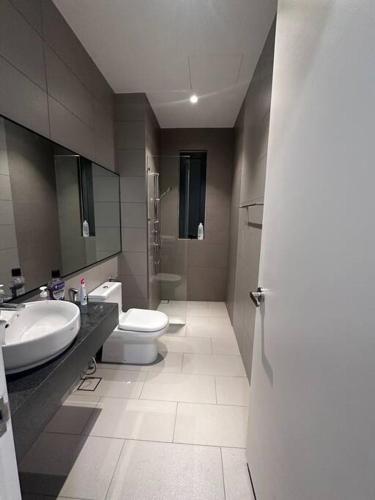 a bathroom with a toilet and a sink at La Cassia - Comfortable, spacious, holiday home in Putrajaya