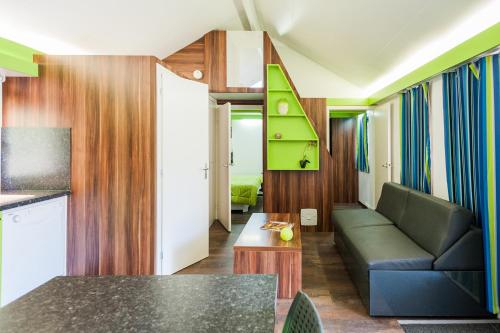 a living room with a couch and a table at Lodges Méditerranée in Vendres-Plage