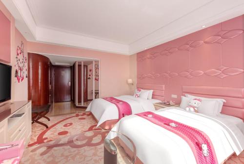 a pink bedroom with two beds and a television at Plaza Hotel Yuyao in Yuyao
