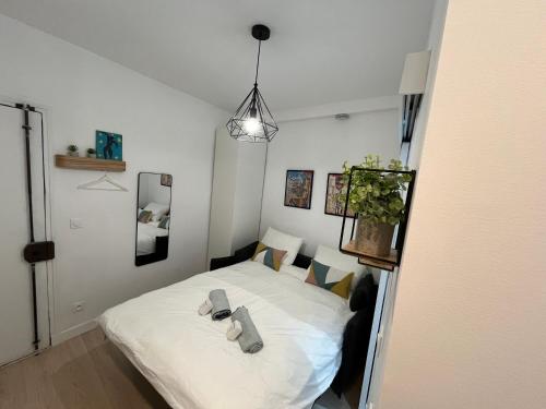 une chambre avec un lit blanc avec des serviettes dessus dans l'établissement Oberkampf by Melvane 18, à Paris