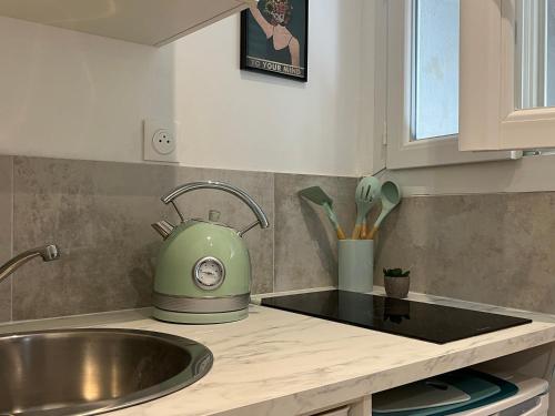 une cuisine avec un évier et une bouilloire à thé vert dans l'établissement Oberkampf by Melvane 18, à Paris