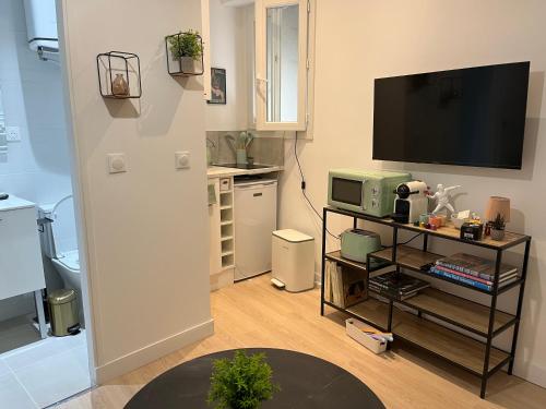 Il comprend un salon avec une télévision et une cuisine. dans l'établissement Oberkampf by Melvane 18, à Paris