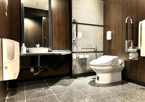 a bathroom with a toilet and a sink at APA Hotel Kobe Sannomiya in Kobe