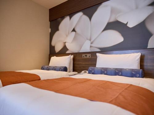 Ένα ή περισσότερα κρεβάτια σε δωμάτιο στο Okinawa NaHaNa Hotel & Spa