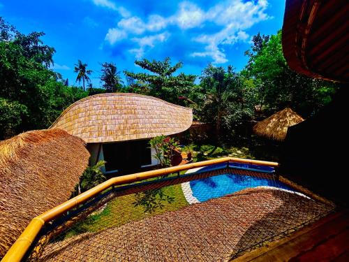 a resort with a swimming pool and an umbrella at Villa Samyama in Gili Air