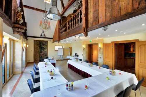 a conference room with white tables and blue chairs at Ringhotel Alpenhof - Patchworkhotel in Augsburg