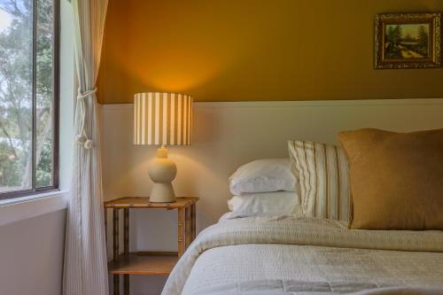 a bedroom with a bed and a lamp on a side table at Poppy's Place - Denmark in Denmark