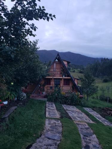 a log cabin with a stone path in front of it at Chalet Villa Ines un paraiso en las montañas in Duitama