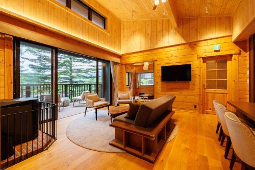 a living room with a couch and a television in a cabin at Karuizawa Asama Prince Hotel in Karuizawa